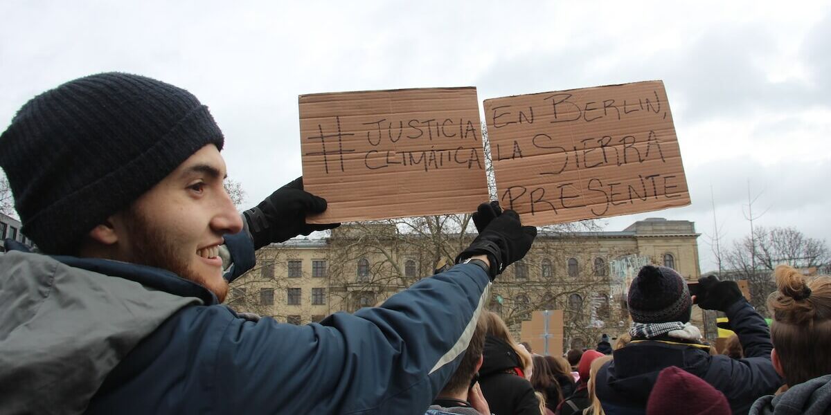Felipe Alberto Corral Montoya at the Global Strike for Future in Berlin holds a sign in solidarity with the community of La Sierra in Colombia where a local protest was taking place, 15 March 2019.  Photo by José Imer Campos